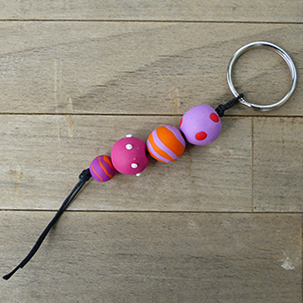 Schlüsselanhänger aus rosa- orangenen- pinkgemusterten Fimokugeln