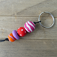 Schlüsselanhänger aus rosa- rot- und orangegemusterten Fimokugeln